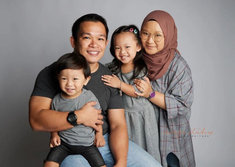 Family smiling together during indoor photoshoot at Orange Studios Singapore