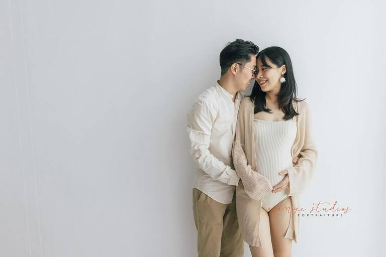 Expecting parents holding hands during maternity shoot at Orange Studios