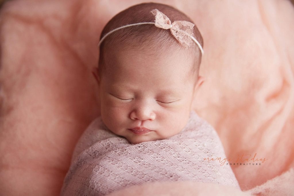 15 days old baby girl on log bed newborn portraits in singapore studio