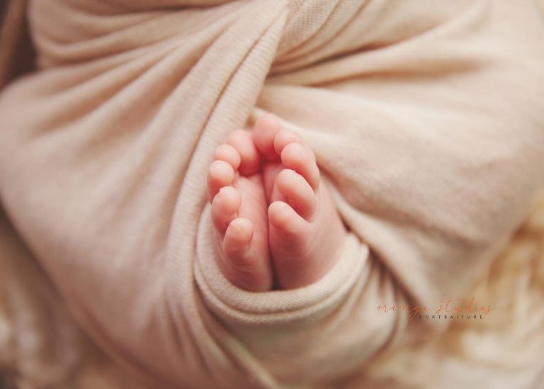 8 days old baby boy peeking toes natural newborn portraits in singapore studio