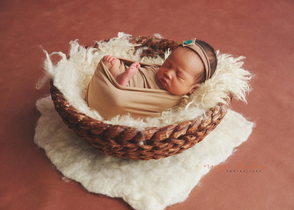 7 days old baby girl newborn portraits in rattan basket in singapore studio