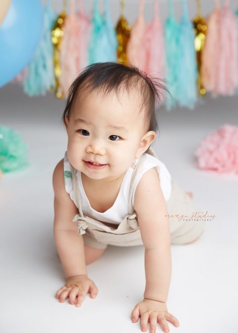 one year old smiling and crawling baby girl portraits in singapore studio