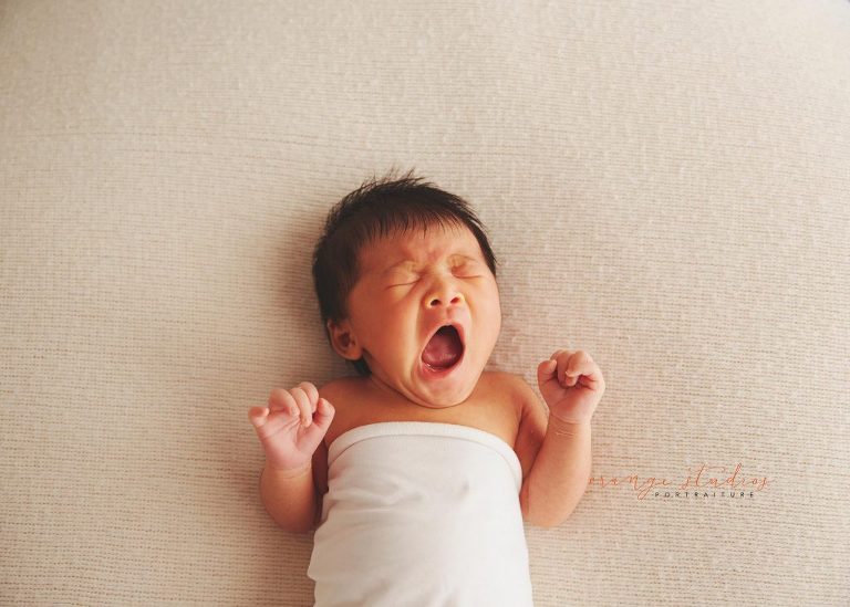 9 days old baby girl yawning natural and clean newborn portraits in singapore studio