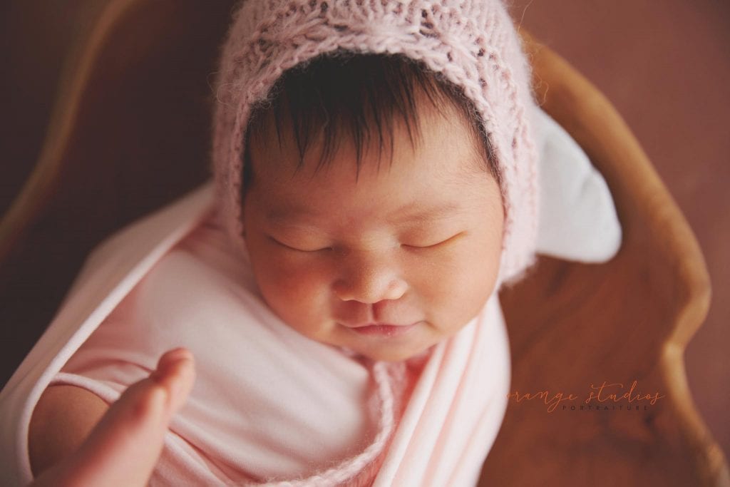 9 days old smiling baby girl newborn portraits in singapore studio