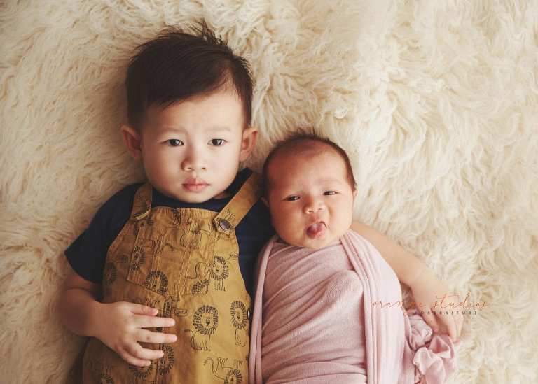 funny 4 weeks old baby girl newborn portraits with elder brother in singapore studio