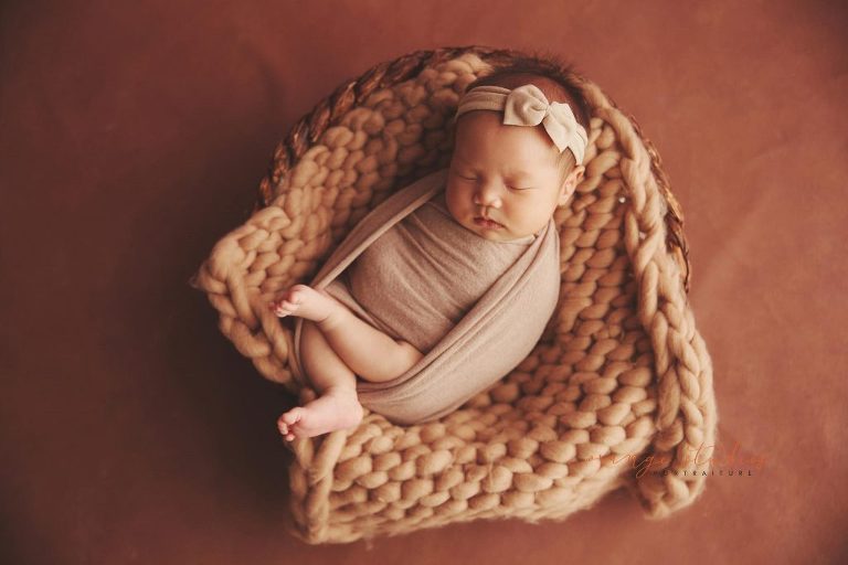 4 weeks old baby girl newborn portraits in rattan basket in singapore studio