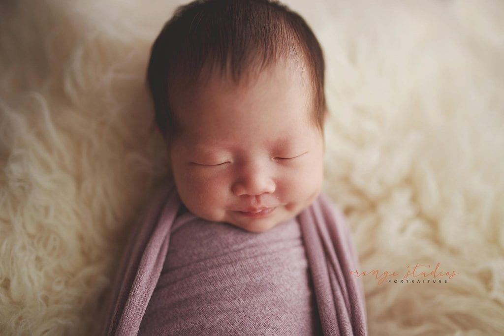 2 weeks old baby girl with dimple newborn portraits in singapore studio