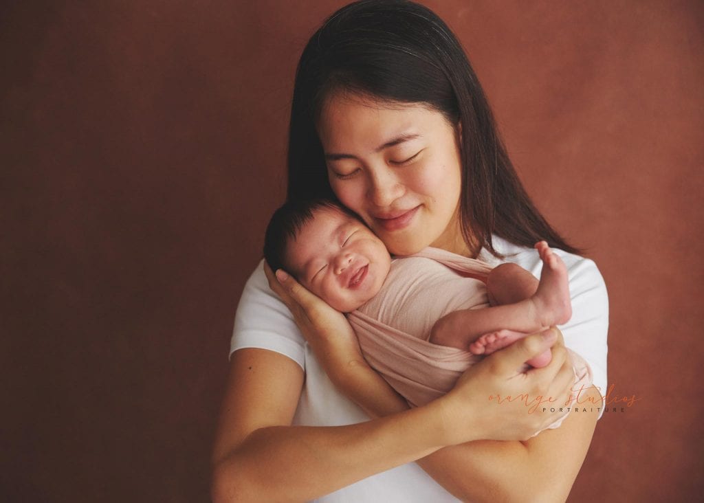 smiling newborn baby girl portraits with mum in singapore home natural lighting