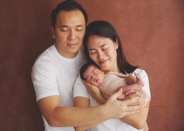 11 days old newborn baby girl portraits with parents in singapore home natural lighting