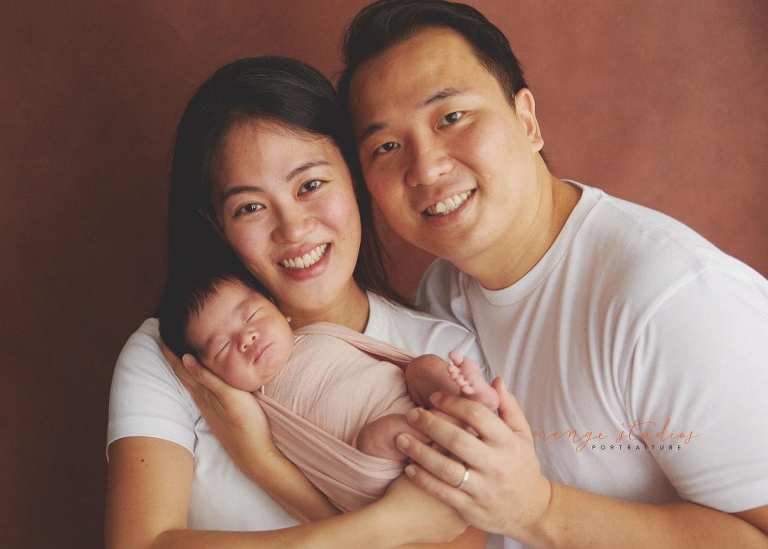 11 days old newborn baby girl portraits with parents in singapore home natural lighting