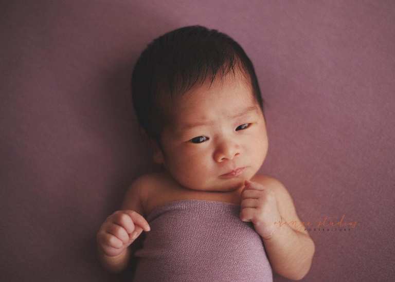 cute 11 days old newborn baby girl looking at camera