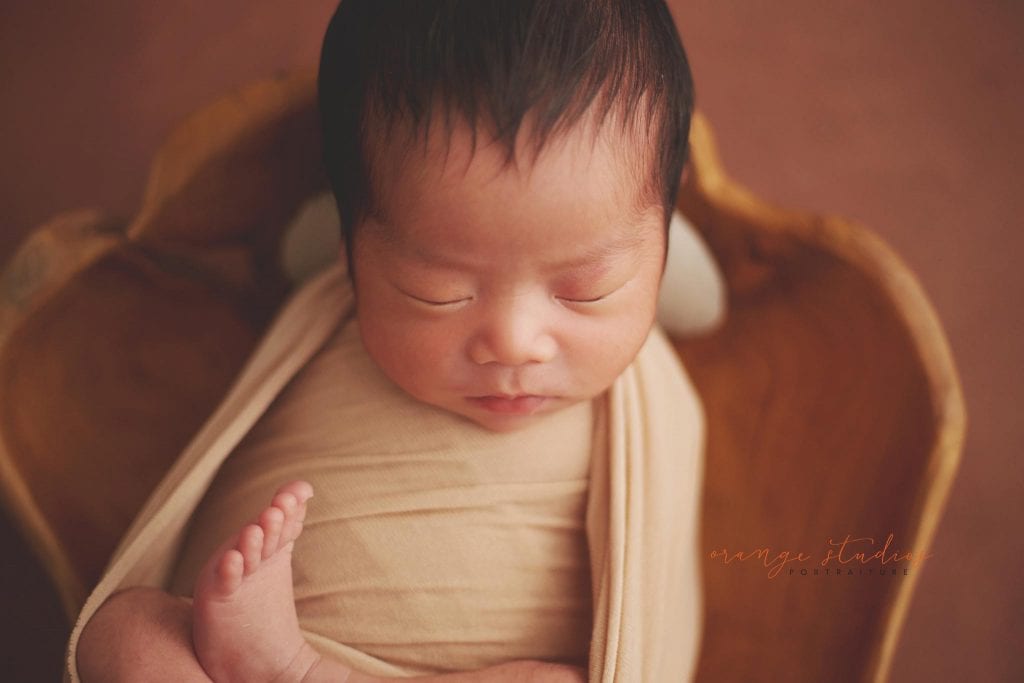 newborn baby in wooden bowl prop in singapore home natural lighting