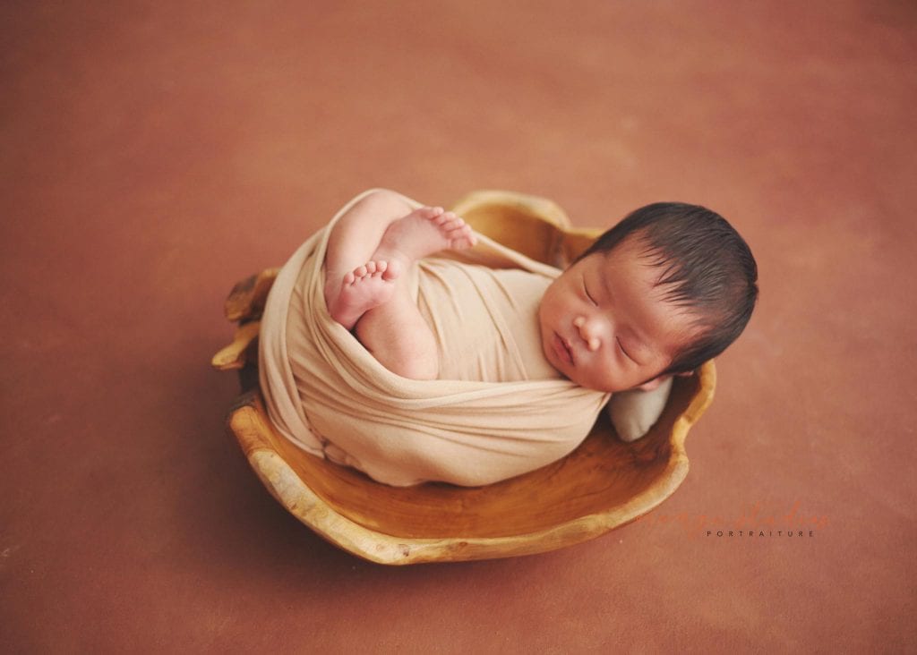 newborn baby in wooden bowl prop in singapore home natural lighting