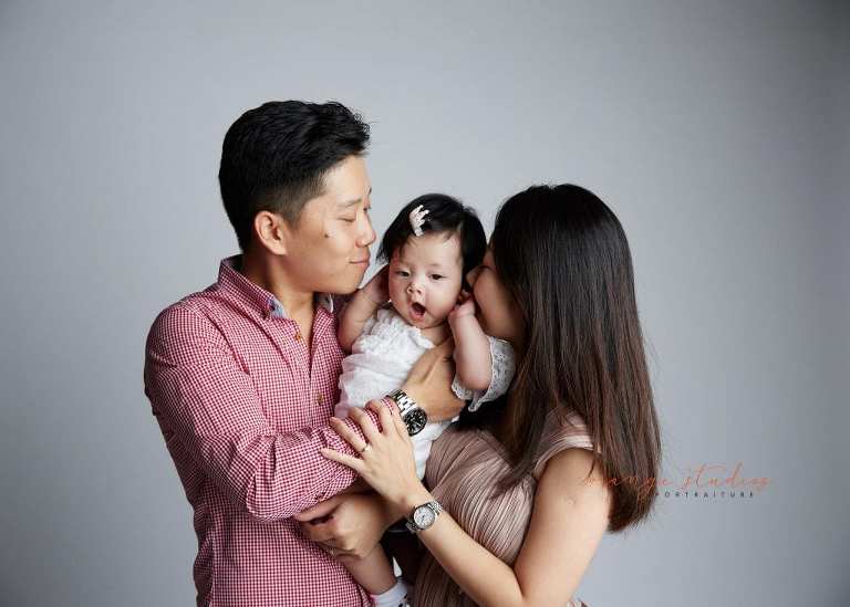 yawning baby girl and parents family portraits in singapore studio