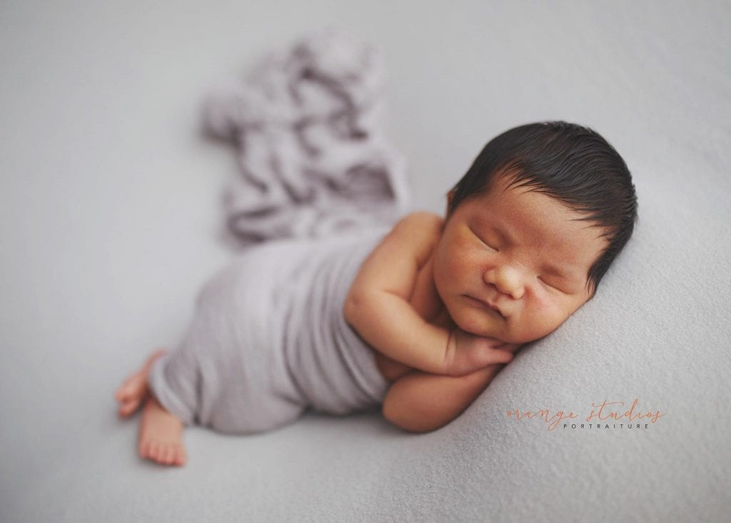 8 days old baby boy side pose newborn portraits in singapore studio