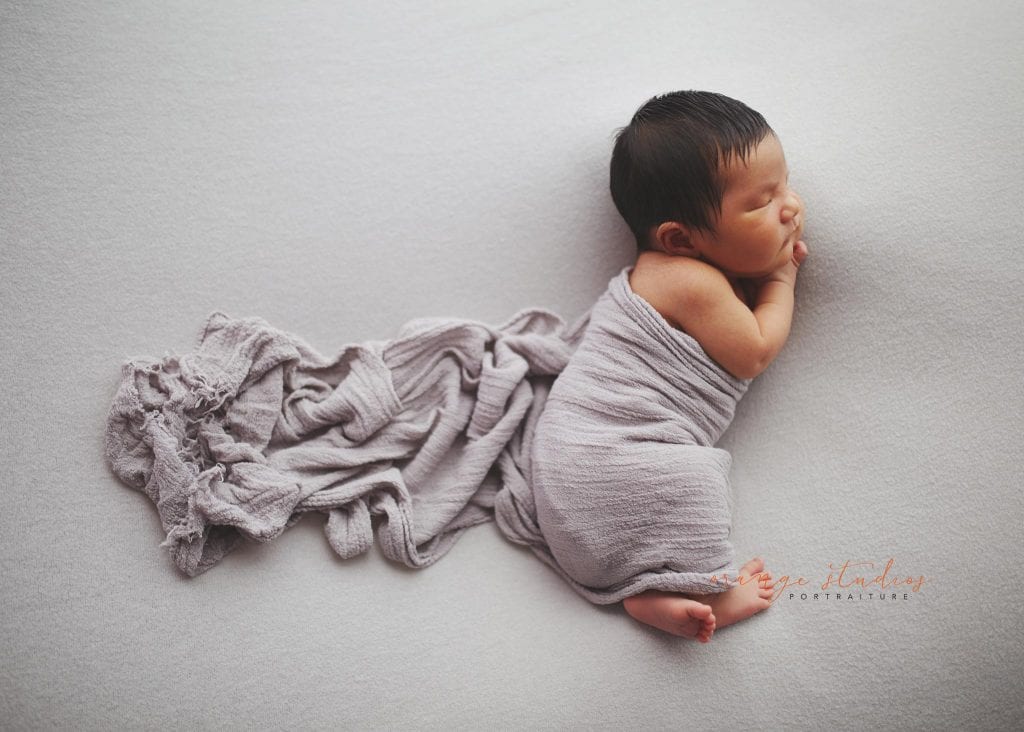 8 days old baby boy side pose newborn portraits in singapore studio