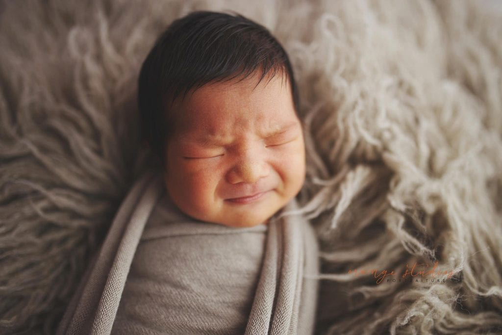 frowning 8 days old baby boy newborn portraits in singapore studio
