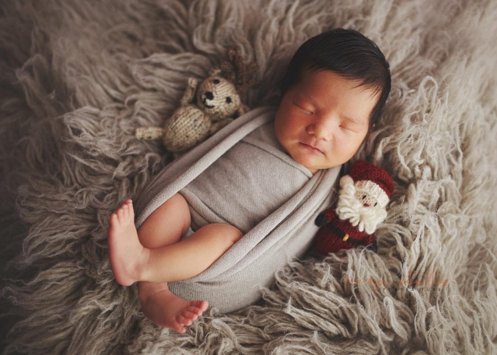 8 days old baby boy with christmas soft toys newborn portraits in singapore studio