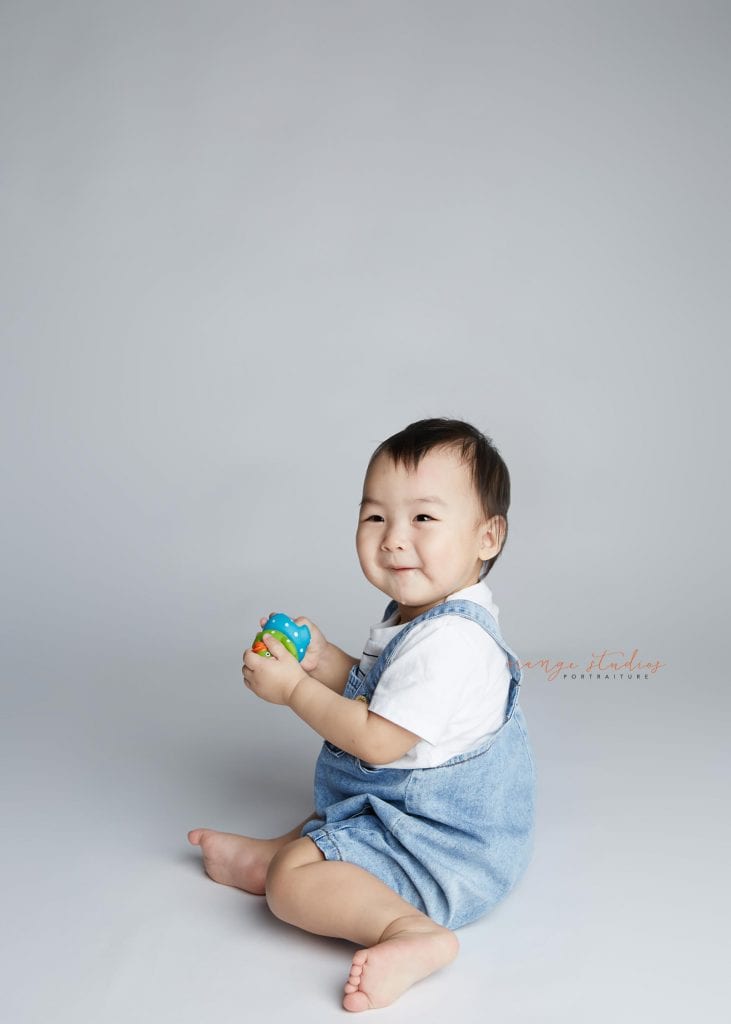smiling 1 year old baby boy portraits in singapore studio
