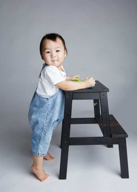 1 year old baby boy standing with support portraits in singapore studio