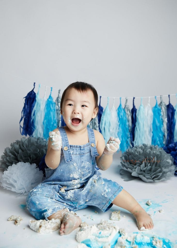 happy 1 year old baby boy cake smash portraits in singapore studio