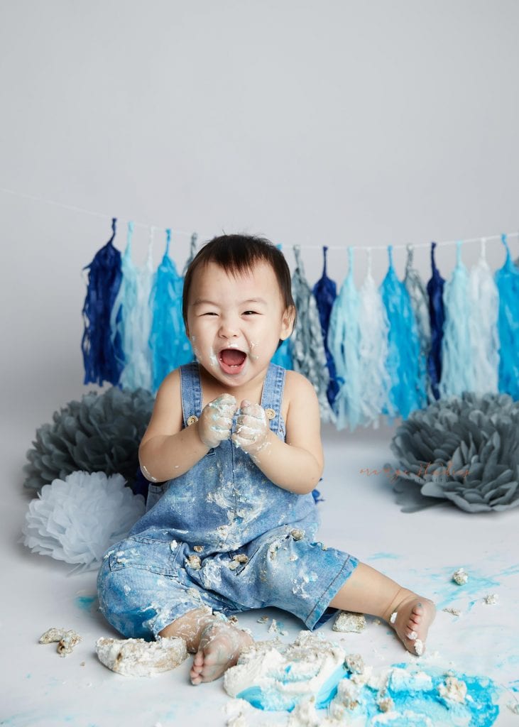 happy 1 year old baby boy cake smash portraits in singapore studio