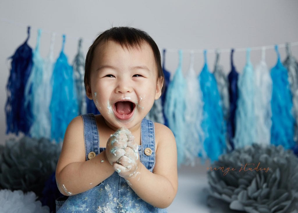 happy 1 year old baby boy cake smash portraits in singapore studio