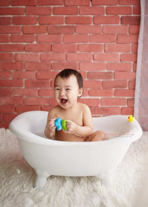 happy 1 year old baby boy bubble bath portraits in singapore studio natural light