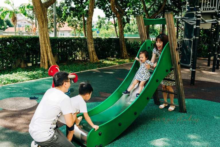 parents playing with kids on the slide in singapore outdoors