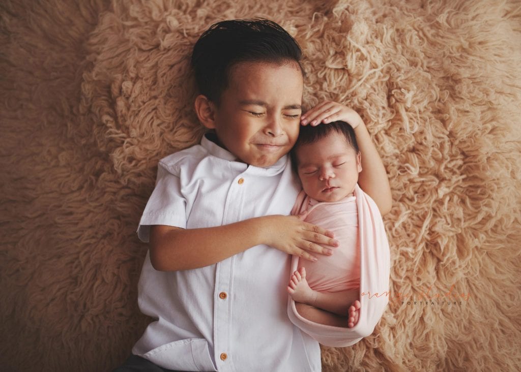 adorable newborn baby portraits with elder brother in singapore studio