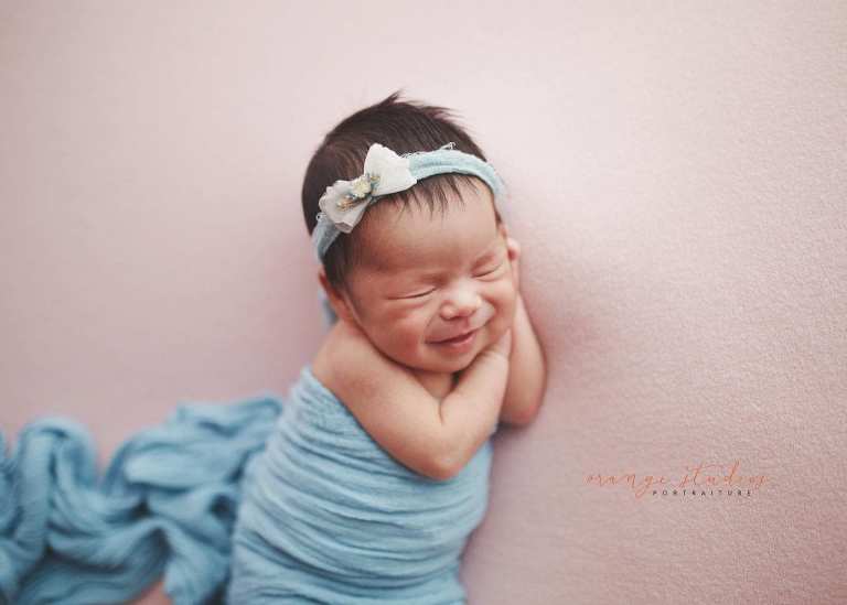 7 days old smiling baby girl newborn portraits in singapore studio