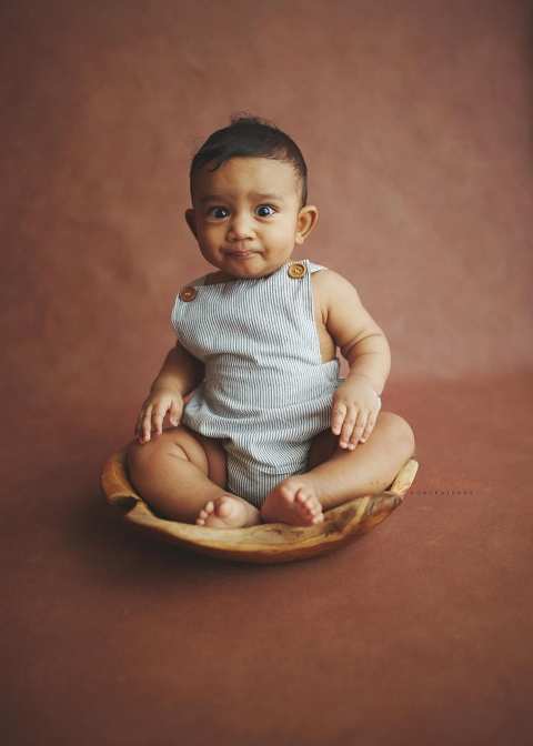 6 months old baby sitting on a wooden bowl portraits in singapore natural light studio