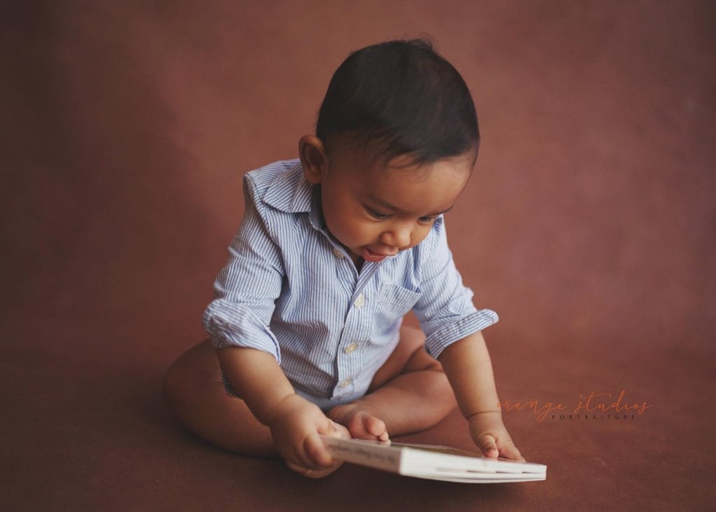 6 months old baby reading a book portraits in singapore natural light studio