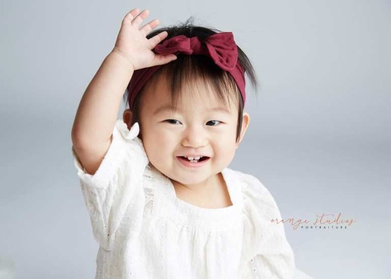 smiling 1 year old baby girl portraits in singapore studio