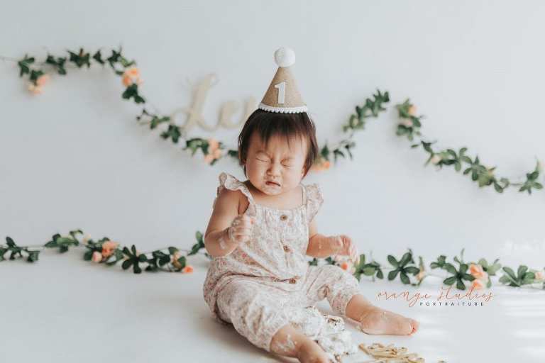 adorable sneezing 1 year old baby girl floral theme cake smash in singapore studio