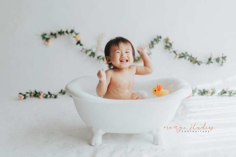 happy 1 year old baby girl bubble bath portraits in singapore studio natural light
