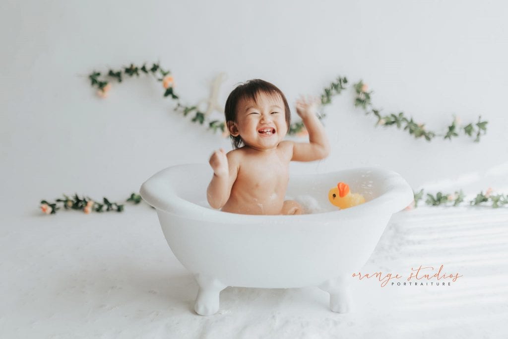 happy 1 year old baby girl bubble bath portraits in singapore studio natural light