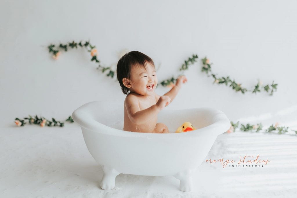 very happy 1 year old baby girl bubble bath portraits in singapore studio natural light