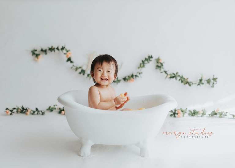 smiling 1 year old baby girl bubble bath portraits in singapore studio natural light