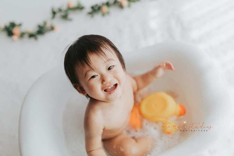 smiling 1 year old baby girl bubble bath portraits in singapore studio natural light