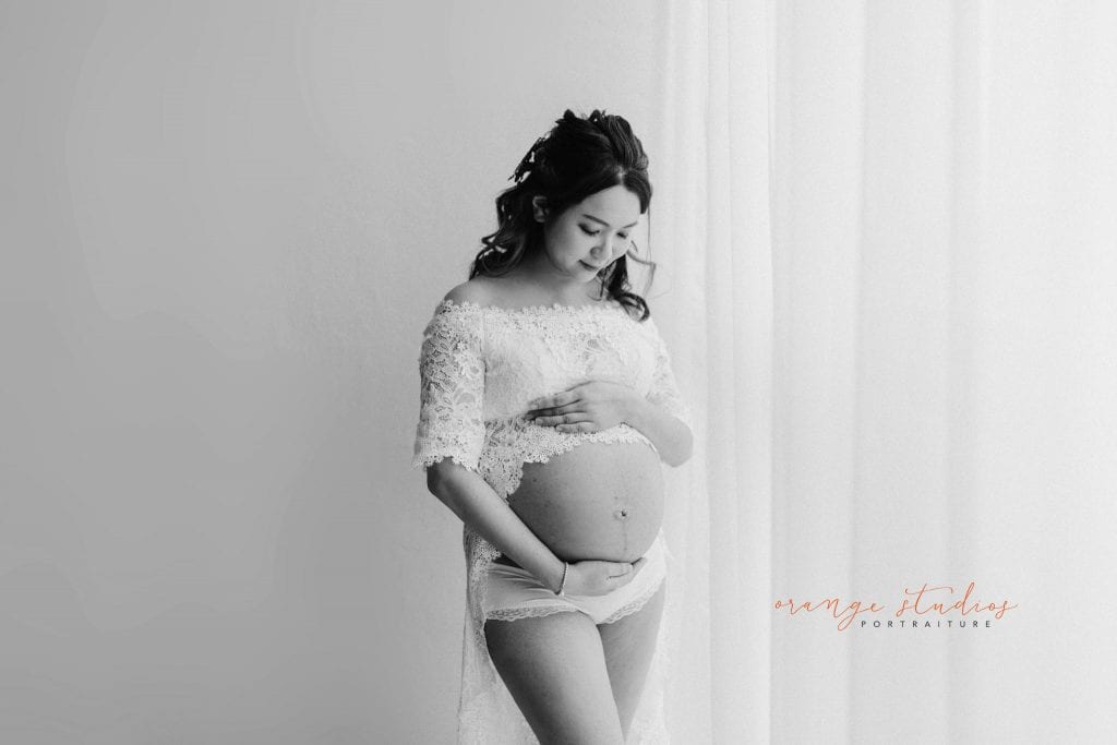 black and white maternity portraits in lacey dress in singapore studio natural light