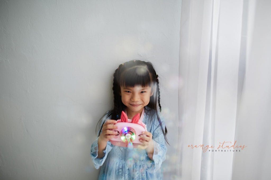 little girl playing with bubbles in singapore natural light studio