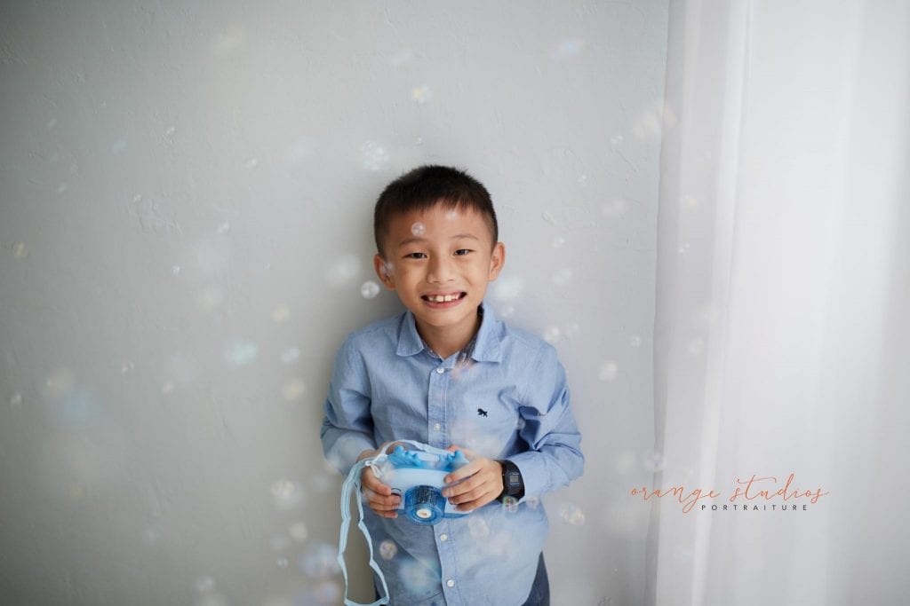 little boy playing with bubbles in singapore natural light studio